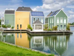 kleurrijke woningen aan het water met zonnepanelen