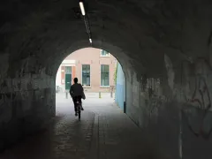 Fietser rijd door donkere tunnel