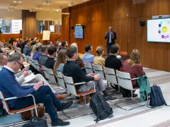 Seminarzaal waar Bert Tieben een publiek toespreekt