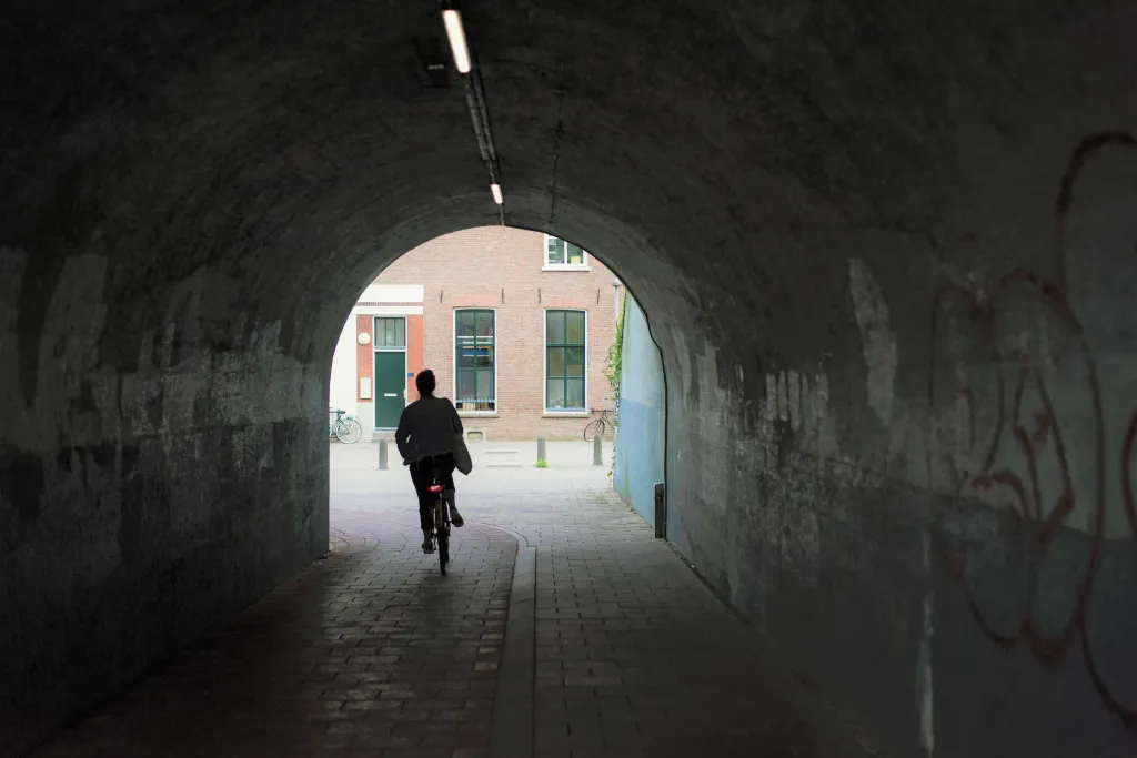 Fietser rijdt door donkere tunnel
